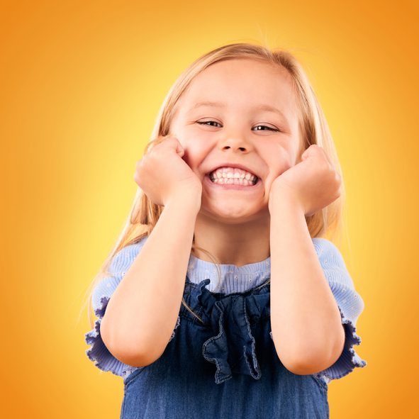 Portrait, child and girl with a smile, surprise and excited on a yellow studio background. Face, person and kid with happiness, announcement and good news with a prize, wow and winner with giveaway